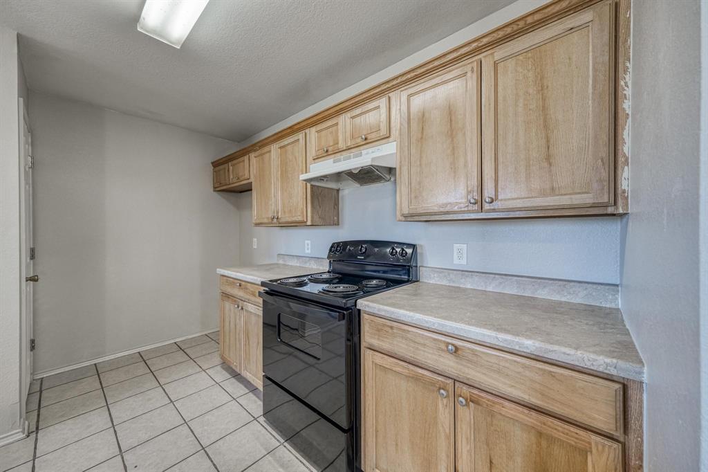 771 Olive Branch Road Weatherford, TX 76087 - Photo 11 of 20 a kitchen with stainless steel appliances granite countertop a stove a sink and a white cabinets