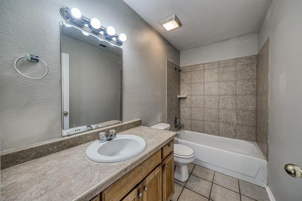 771 Olive Branch Road Weatherford, TX 76087 - Photo 16 of 20 a bathroom with a granite countertop sink a toilet and shower