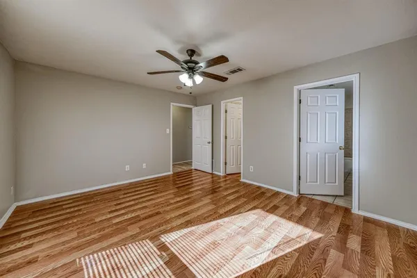a view of a room with a ceiling fan and wooden floor