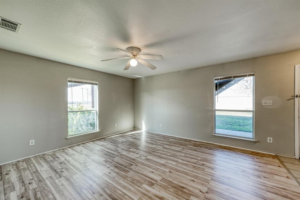 771 Olive Branch Road Weatherford, TX 76087 - Photo 6 of 20 an empty room with wooden floor and windows