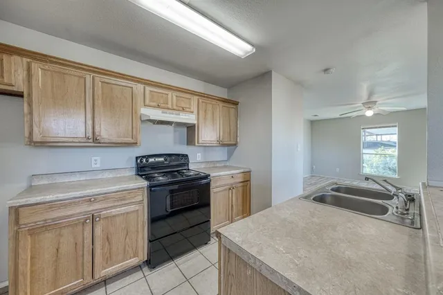 a kitchen with granite countertop white cabinets and stainless steel appliances