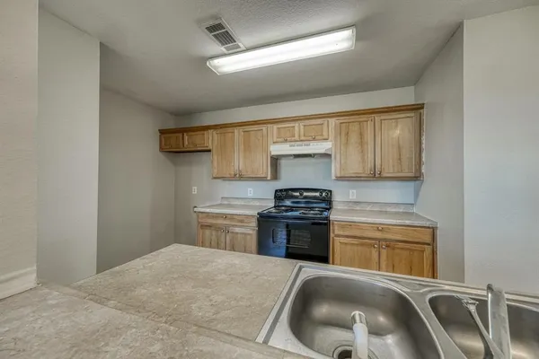 a kitchen with a stove a sink and a refrigerator