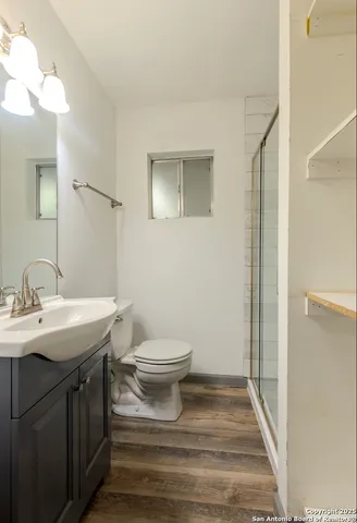 a bathroom with a toilet a sink and mirror