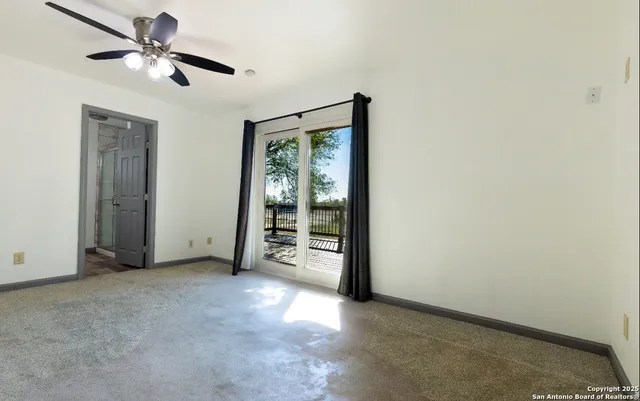 a view of a livingroom with a ceiling fan and window