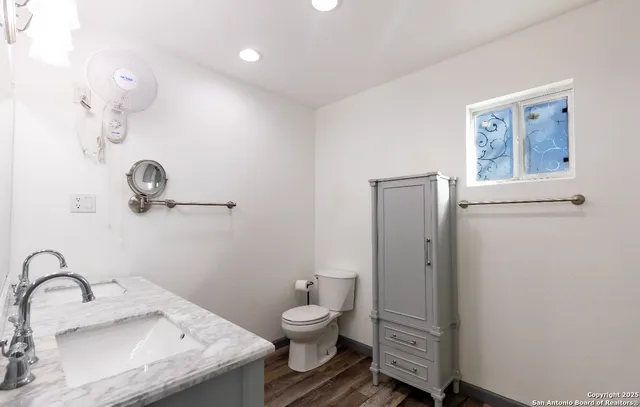 a bathroom with a granite countertop sink toilet and shower