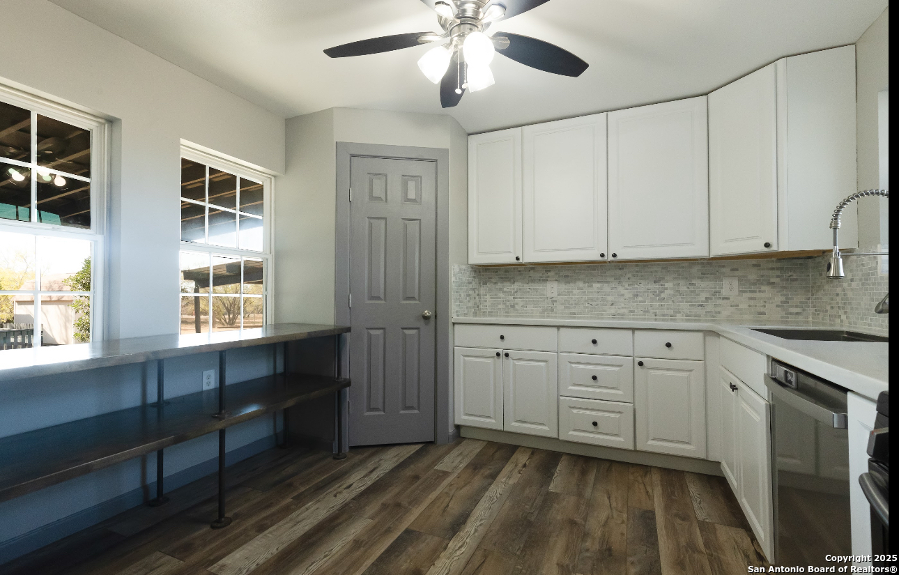 1510 Corgey Road Pleasanton, TX 78064 - Photo 6 of 34 a kitchen with stainless steel appliances granite countertop a stove a sink and white cabinets with wooden floor