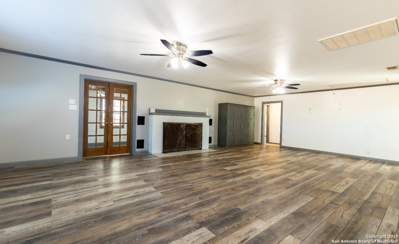 1510 Corgey Road Pleasanton, TX 78064 - Photo 10 of 34 a view of an empty room with window and wooden floor