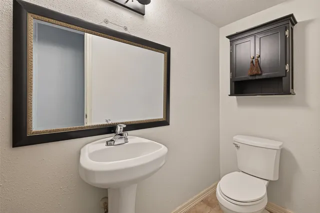 a bathroom with a toilet a sink and mirror