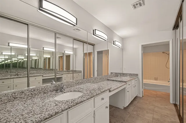 a bathroom with a granite countertop sink and a mirror