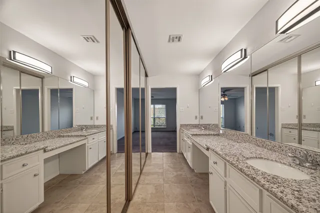 a spacious bathroom with a granite countertop sink mirror and shower