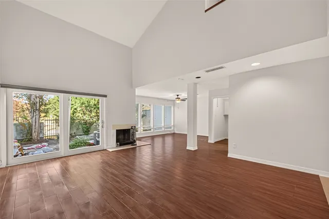 a view of empty room with wooden floor and fireplace
