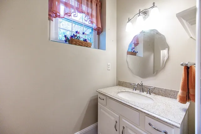 a bathroom with a granite countertop sink and a mirror