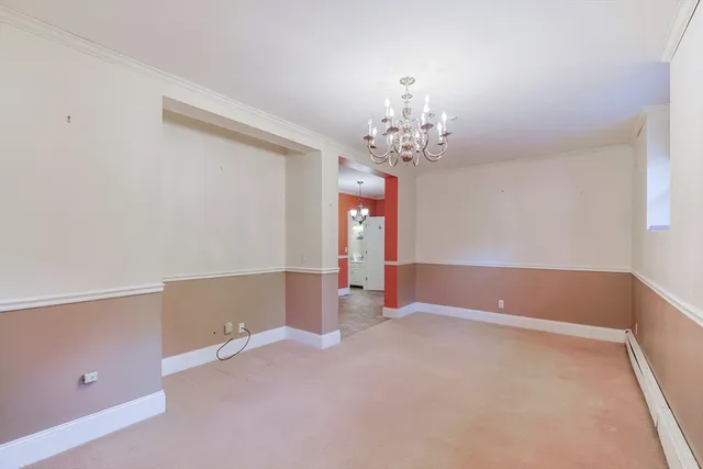 a view of an empty room with chandelier and a window