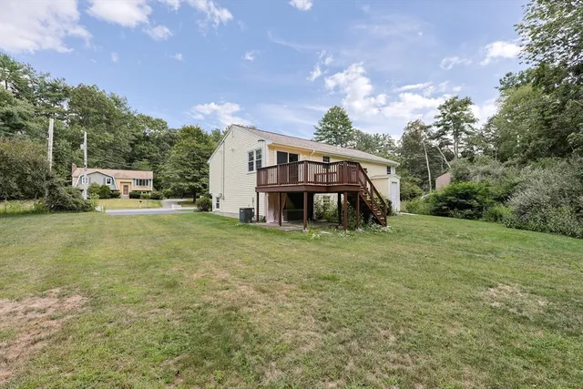 a view of a big house with a big yard and large trees