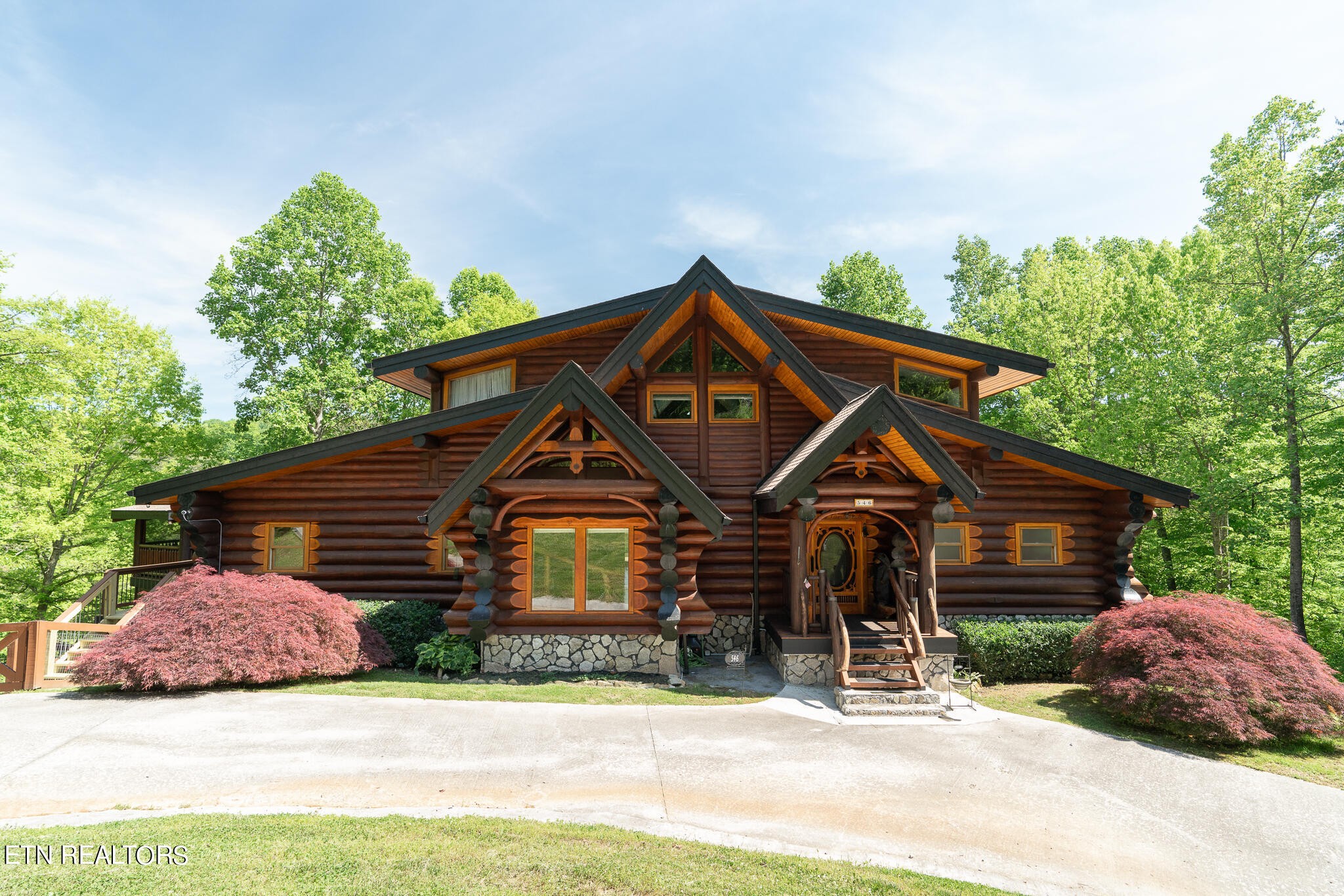 a front view of a house with a garden and trees