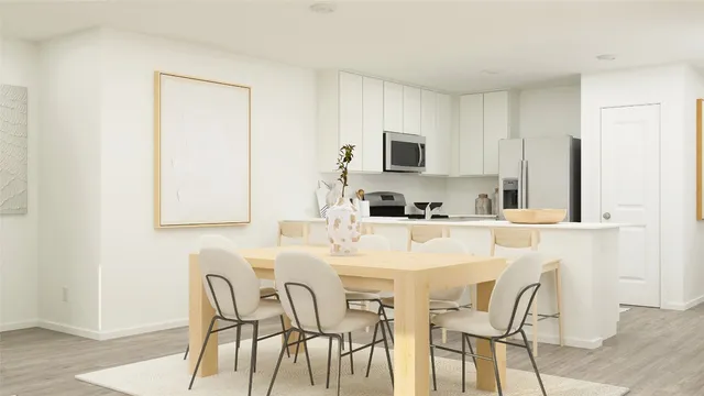 a kitchen with stainless steel appliances granite countertop a white table and chairs