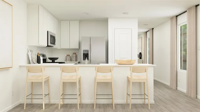 a white kitchen with stainless steel appliances granite countertop a stove a sink refrigerator and white cabinets with wooden floor