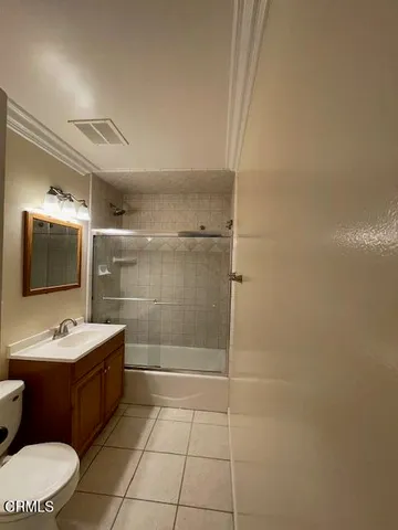 an empty room with wooden floor chandelier fan and windows