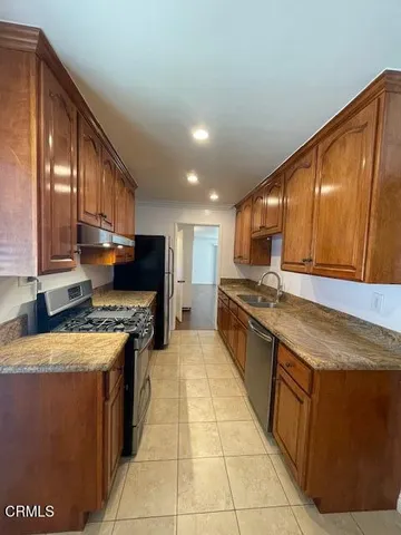 a large kitchen with stainless steel appliances granite countertop a stove a sink and a refrigerator