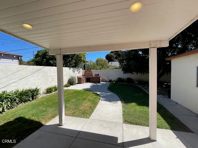 a patio with table and chairs and potted plants