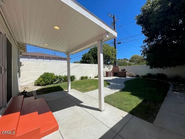 a view of a patio with table and chairs potted plants with wooden floor and fence