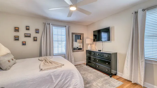 a bedroom with a bed and a flat tv screen on dresser