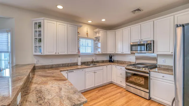 a kitchen with granite countertop a stove sink and cabinets