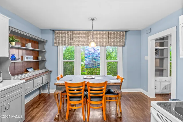 a view of a dining room with furniture a rug and wooden floor