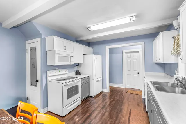 a kitchen with stainless steel appliances granite countertop a stove a sink dishwasher and a refrigerator with wooden floor