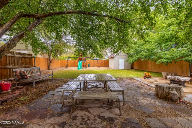 a view of a backyard with table and chairs under an umbrella