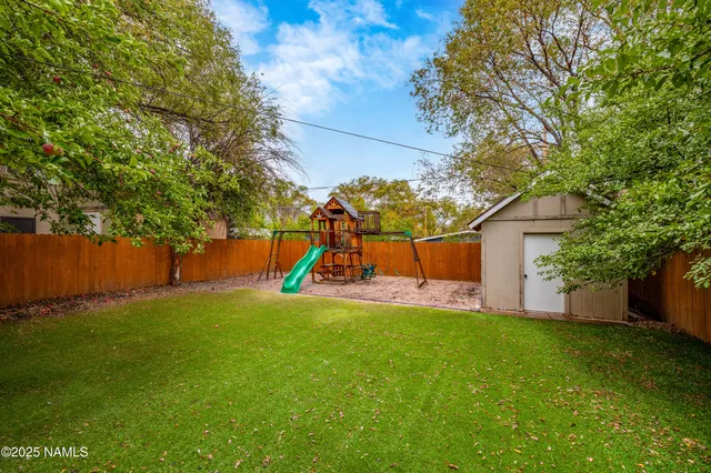 a view of a house with a yard and tree