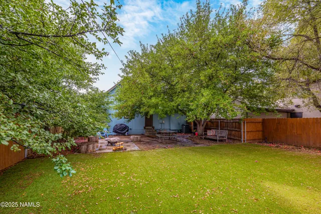 a backyard of a house with fountain table and chairs