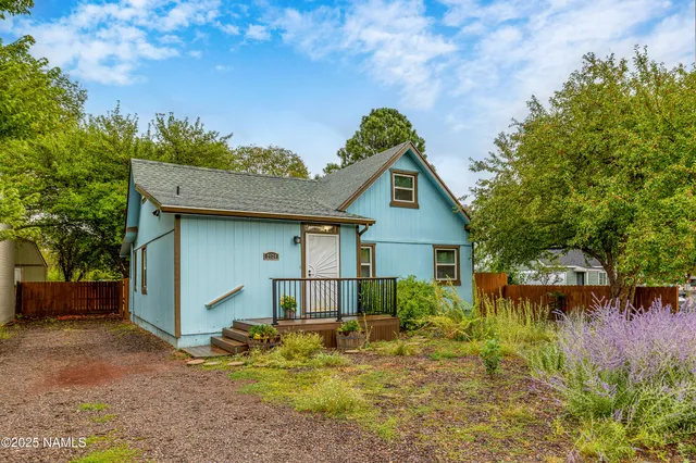 a view of a house with pool and chairs next to yard
