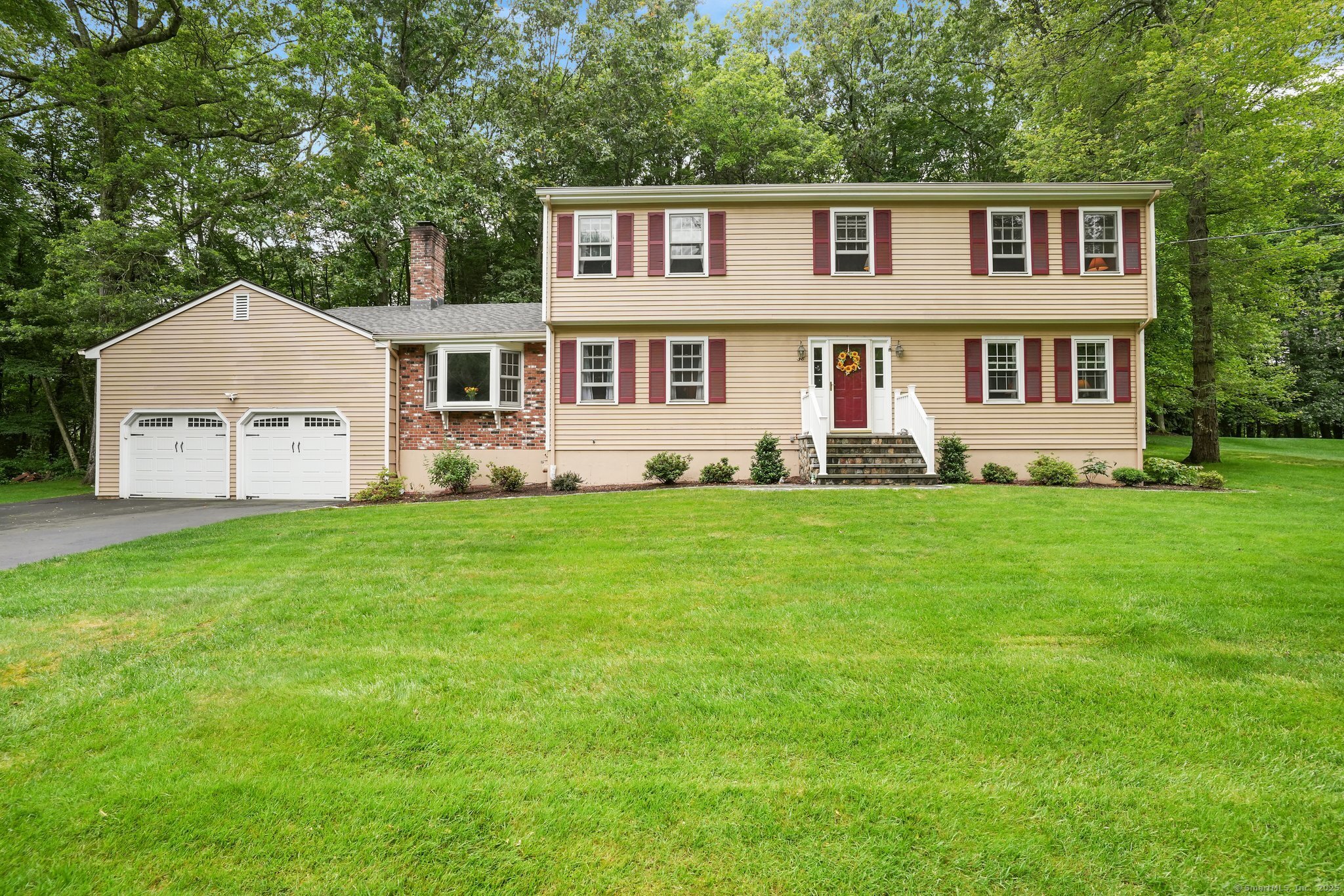 a front view of a house with a yard and trees