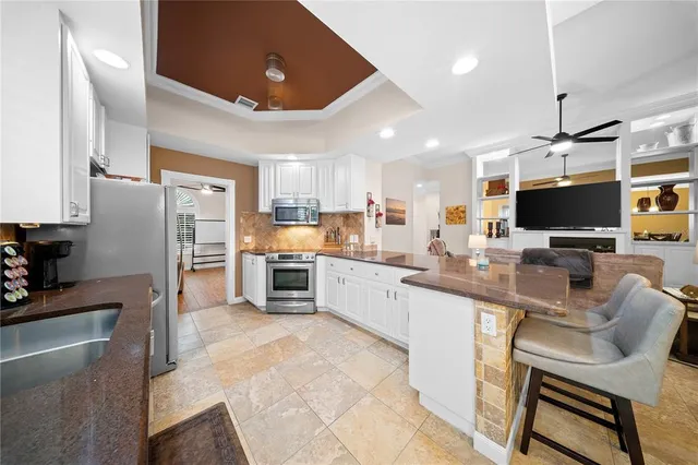 a kitchen with stainless steel appliances kitchen island granite countertop a sink and cabinets