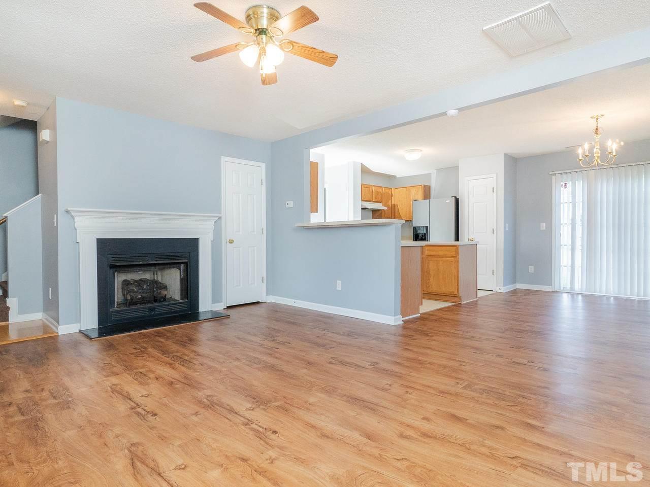 5801 Weddington Road Raleigh, NC 27610 - Photo 8 of 28 a view of empty room with wooden floor and fireplace