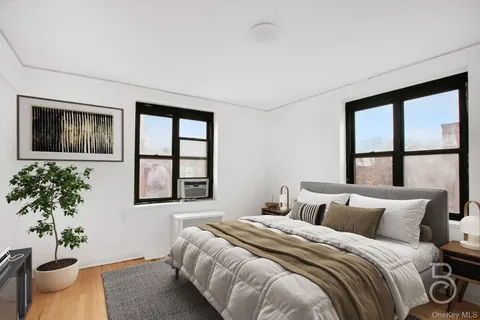 a bedroom with a large bed and a potted plant