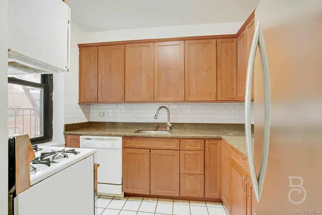 a kitchen with metallic refrigerator freezer and a dishwasher oven