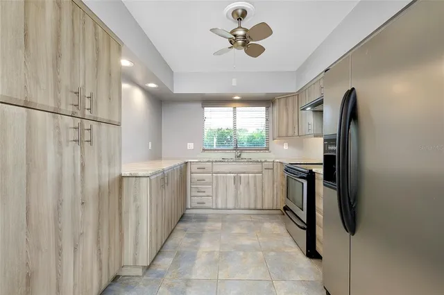 a kitchen with granite countertop cabinets sink and window