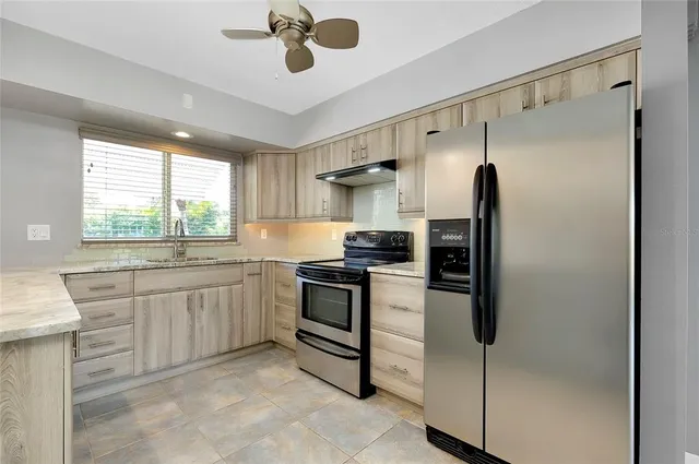 a view of kitchen with granite countertop sink and window