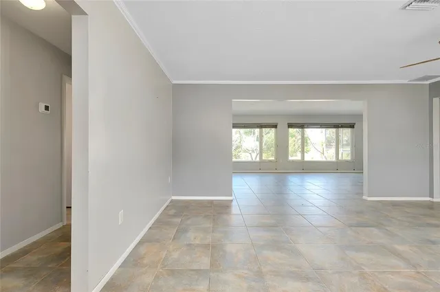 an empty room with a window and a ceiling fan