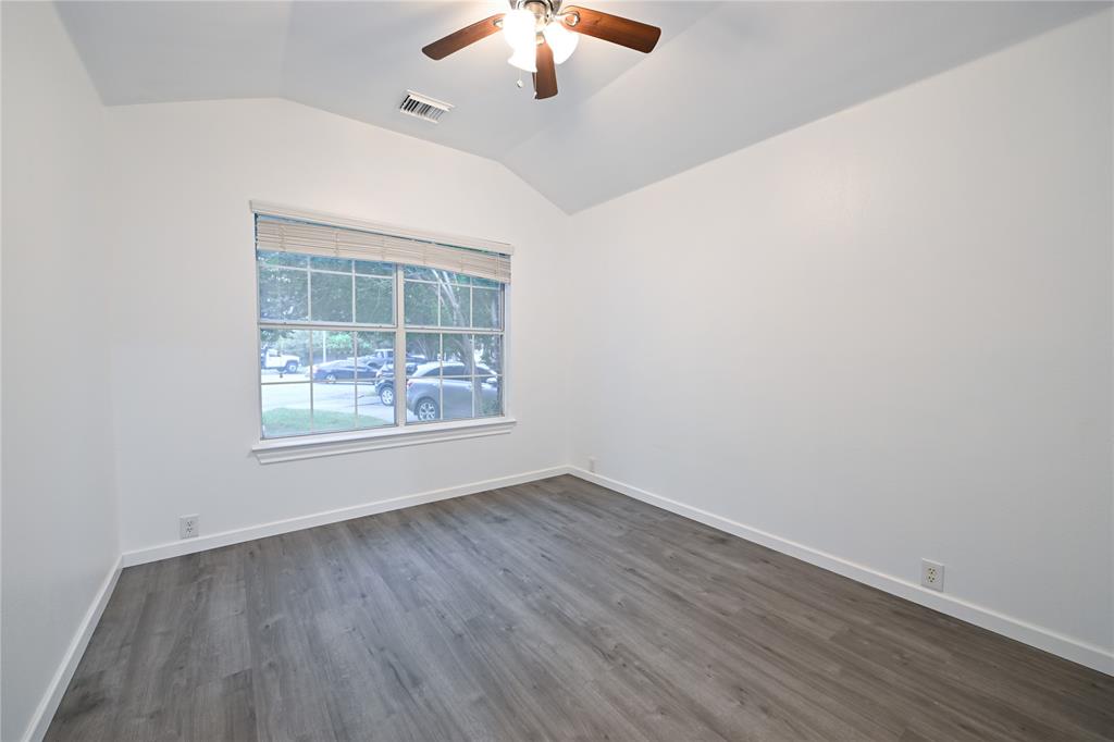 910 Rocking Spur Cove Pflugerville, TX 78660 - Photo 3 of 17 A well-lit room with vaulted ceilings and a window providing street views, complete with modern laminate flooring.