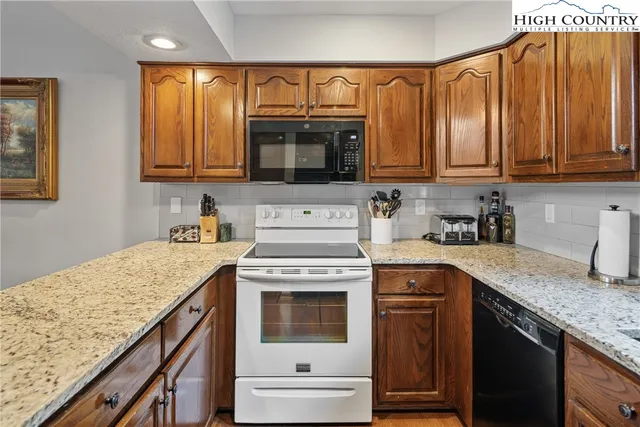 a kitchen with granite countertop a sink stove and cabinets