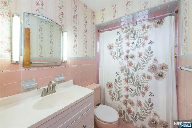 a bathroom with a sink a toilet and shower curtain