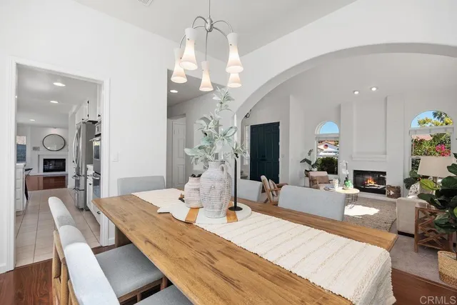 a view of a dining room with furniture a chandelier and wooden floor