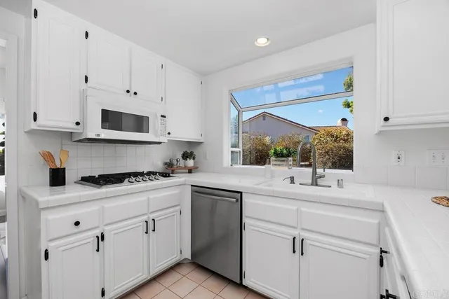 a kitchen with white cabinets and white appliances