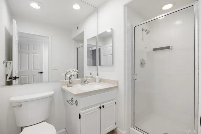 a bathroom with a sink toilet vanity and shower