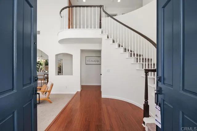 a view of staircase with wooden floor and a chandelier