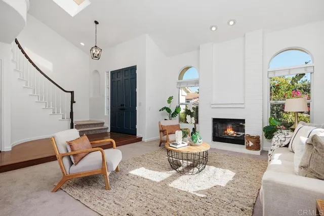 a living room with furniture a fireplace and a potted plant
