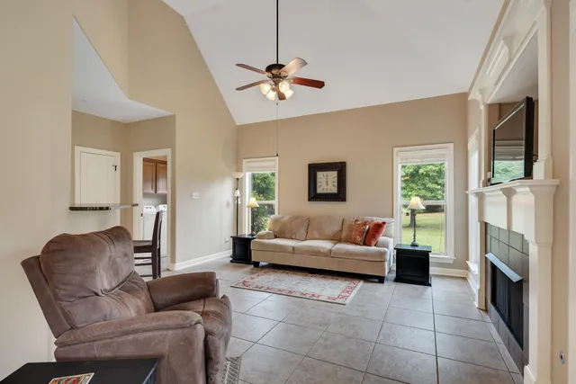 a living room with furniture a flat screen tv and a fireplace
